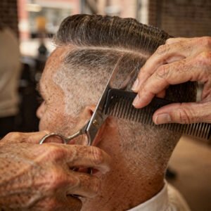 flux pro 2.0 extreme close up of a barber cutting an older man’s hair with scissors and com 0