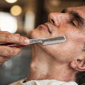 flux pro 2.0 extreme close up of a barber performing a traditional shave with a straight razo 0