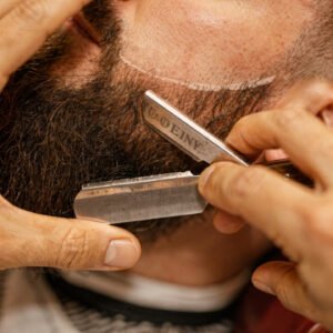 flux pro 2.0 extreme close up of a barber trimming and shaping a beard with scissors and comb 0